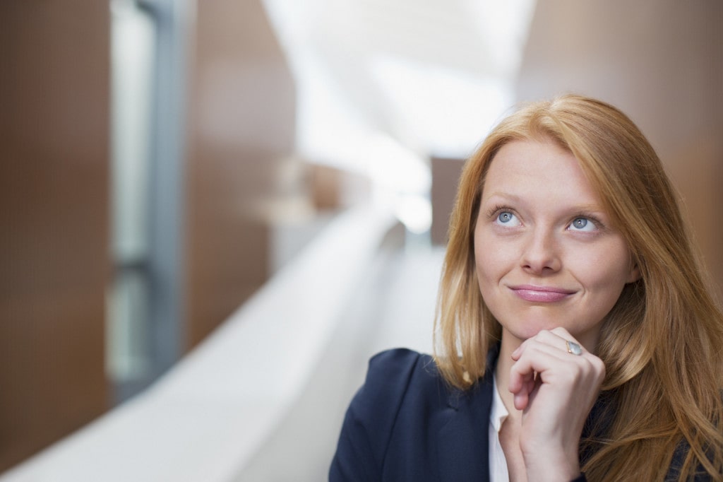 Portrait of pensive businesswoman looking up